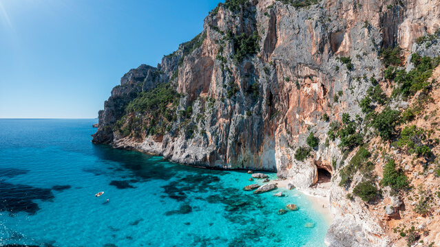 Aerial view of Piscine di Venere on the coast of Baunei, Sardinia, Italy. Crystal-clear turquoise water, white sandy beach and dramatic limestone cliffs along the Gulf of Orosei.