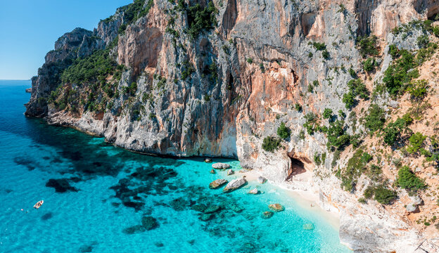 Aerial view of Piscine di Venere on the coast of Baunei, Sardinia, Italy. Crystal-clear turquoise water, white sandy beach and dramatic limestone cliffs along the Gulf of Orosei.