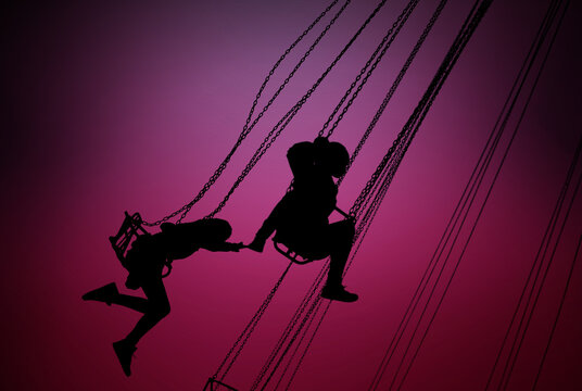 silhouettes of young girls having fun on carousel
