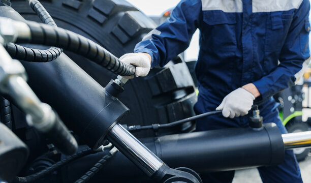 Worker mechanic Diagnostics pipe system of hydraulic hose valves in industry machinery truck