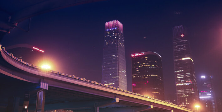 Neon City Skyline with Highway Overpass at Night