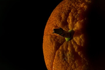 Orange fruit detail with shiny black table and white salt
