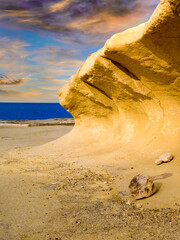 Curved sandstone formation on the coast of Zebbug on Gozo, Malta, with sea view at sunset