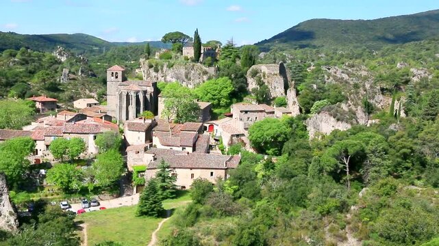Village de Mour&egrave;ze avec ses maisons group&eacute;es autour de l'&eacute;glise et du rocher.
