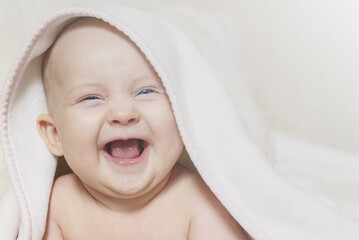 Adorable Laughing Baby Peeking from Under White Blanket with Joyful Expression