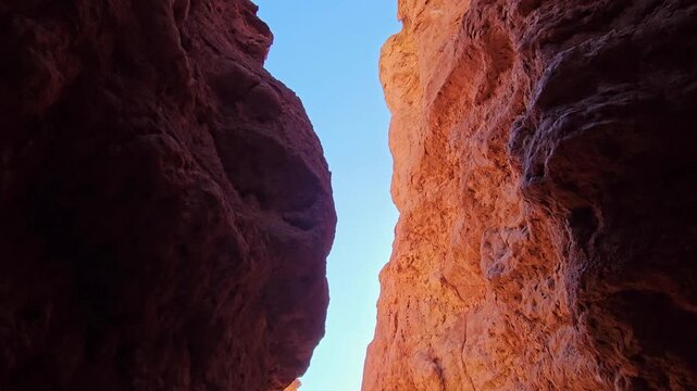 Majestic res sandstone rock formations arranged in a slit canyon in Kyrgyzstan Kokpak Kyrkoo location. Pan down handheld shot.