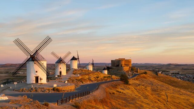 Golden sunrise timelapse over the historic windmills and castle of Consuegra in La Mancha, Spain