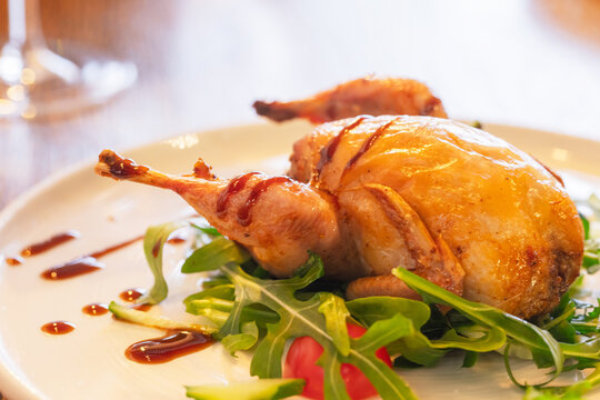 A whole baked quail with herbs and vegetables, close up photography