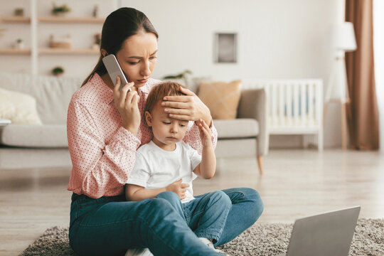 Call to pediatrician. Stressed mother talking to doctor, worried about her son's health, checking child's temperature by holding hand on kid forehead. Remote healthcare consultation.