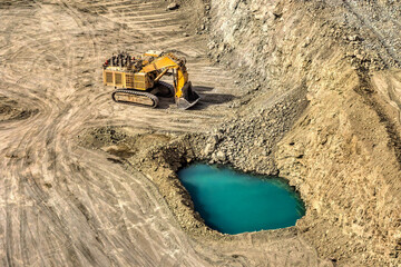 Yellow Hydraulic Mining Shovel Excavator Operating in Open Pit Mine, rocky terrain