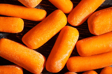 baby carrots on black wood background top view