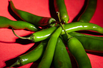 green chili pepper on red background