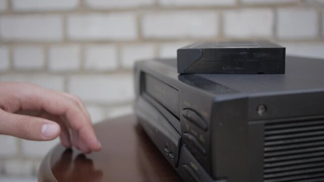 Close Up Of Hand Ejecting Vhs Cassette Tape From Video Player
