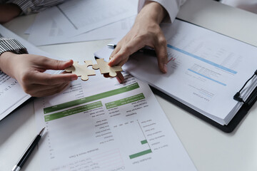 Hands interlock puzzle pieces to symbolize unity teamwork and corporate success