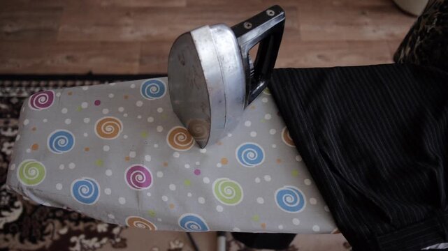 View Of Old-Style Metal Iron On An Ironing Board