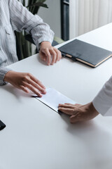 Business people giving a resign letter to quit a job at office