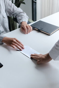 Business people giving a resign letter to quit a job at office