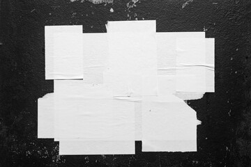 White torn posters on a black background close-up
