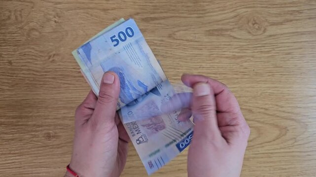 Person counting banknotes, Mexican pesos. Economics concept