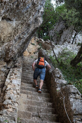 A man climbs the stairs to the Faro del Caballo lighthouse, Cantabria. Walking in nature