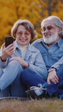 Mature people having online coversation in autumn park