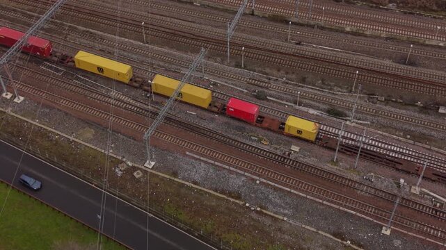 Rail Transport Symphony: An elevated perspective captures the organized ballet of a freight train gliding along parallel tracks, laden with colorful cargo containers.