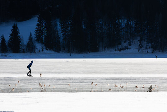 silhouette of an ice skater on a frozen lake in winter