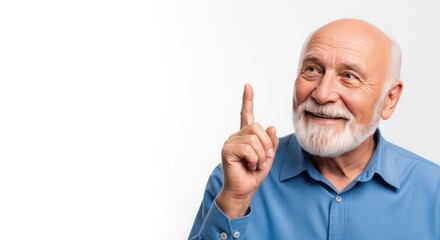 Elderly man shares an idea with a smile indoors while pointing his finger in the air