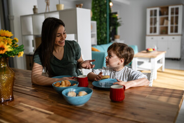 Fototapeta premium Mother and son enjoying family breakfast at home