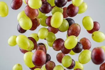 fresh green and red grapes falling on white background