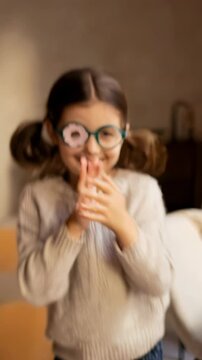 Happy little girl with an eye patch on prescription glasses playing around, showcasing child ophthalmology and vision correction Vertical video