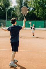 Man serving tennis ball on clay court