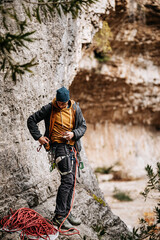 Obraz premium Male Rock Climber Adjusting Harness And Carabiners: Safety Gear Preparation In Golle Della Stretta Sicily Italy