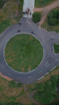 Roundabout Amid Trees. Aerial Perspective Of Lush Green Circular Junction. Elevated Perspective Highlighting Dense Forest Surrounding Circular Traffic Circle With Natural Buffer Zones