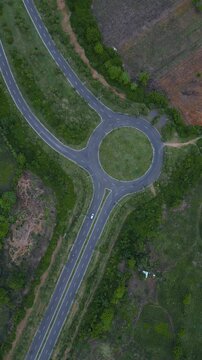 Roundabout Amid Trees. Aerial Perspective Of Lush Green Circular Junction. Elevated Perspective Highlighting Dense Forest Surrounding Circular Traffic Circle With Natural Buffer Zones