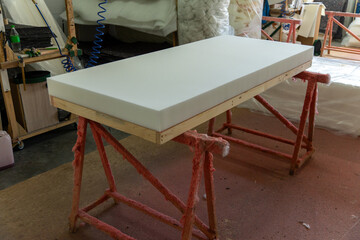 Foam mattress core on wooden frame in upholstery workshop