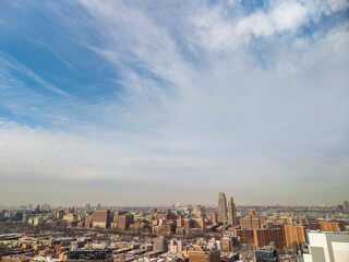 Naklejka premium New york city cityscape offering a wide aerial view of harlem's dense residential buildings and architectural diversity under a cloudy sky, showcasing the expansive urban development in manhattan
