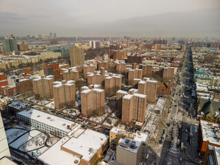 Harlem's residential blocks and urban landscape covered in snow, overlooking adam clayton powell jr blvd and a dense cityscape stretching towards the horizon in new york city