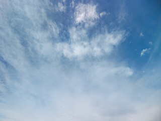 Obraz premium Soft cirrus clouds drift gracefully through a bright blue sky above new york, creating a serene and peaceful atmosphere that highlights the beauty of natural light and open air