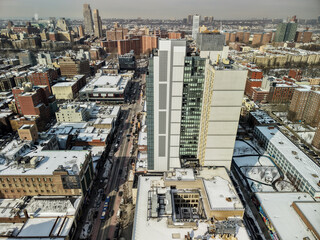 Fototapeta premium New york city aerial view of adam clayton powell jr. Blvd and surrounding harlem apartment buildings blanketed in winter snow, highlighting dense urban life and architecture