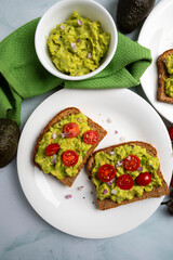 Overhead composition of avocado toast served on plates with cherry tomatoes, avocado spread, and simple table styling. The balanced layout and negative space make this image ideal for food blogs, edit