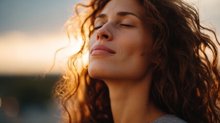 Woman closing eyes and feeling peaceful in natural light. Experiencing calm and wellness during a beautiful sunset
