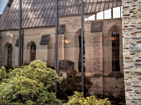 Angers, France - August 3rd 2012: View of the Mus&eacute;e David d'Angers reflected in the glass facade of a nearby building in the city center.