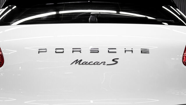White Porsche Macan S, close-up of trunk, headlights, bumpers, rear view. The logo on the trunk lid. Rear view of the brand new Porsche Macan S. German SUV car.