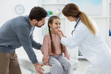 Obraz premium Little girl and her father having appointment with pediatrician in hospital. Doctor examining child
