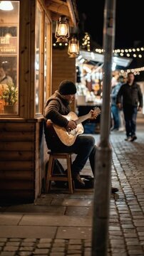Street musician playing acoustic guitar on a cinematic nighttime cobblestone street with warm lanterns and festive market lights for authentic urban lifestyle and local culture concept