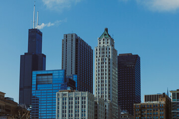 Skyscrapers rise against a clear blue sky over downtown Chicago during daytime hours showing city life and architecture