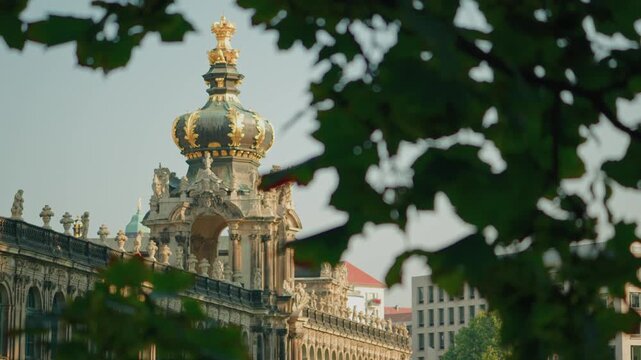 A scene transition from leaf to the Kronentor (Crown Gate), the famous entrance to the Zwinger Palace in Dresden, Germany, taken under the shade of trees