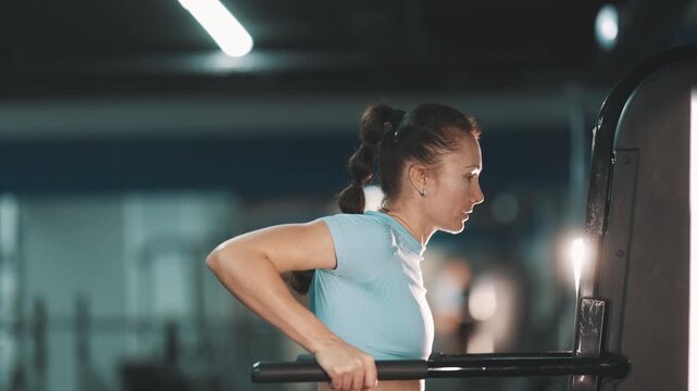 Strong woman training triceps on parallel bars