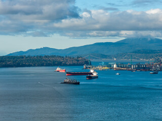 Obraz premium Vancouver Harbor Scene With Cargo Ships, Bridge, and Mountain Backdrop in British Columbia
